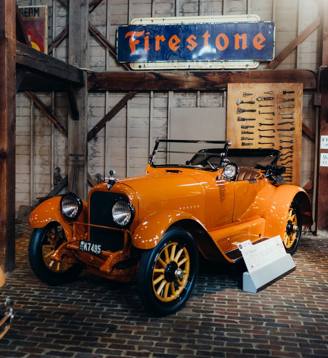 Historic brick garage with a restored vintage automobile and old tools