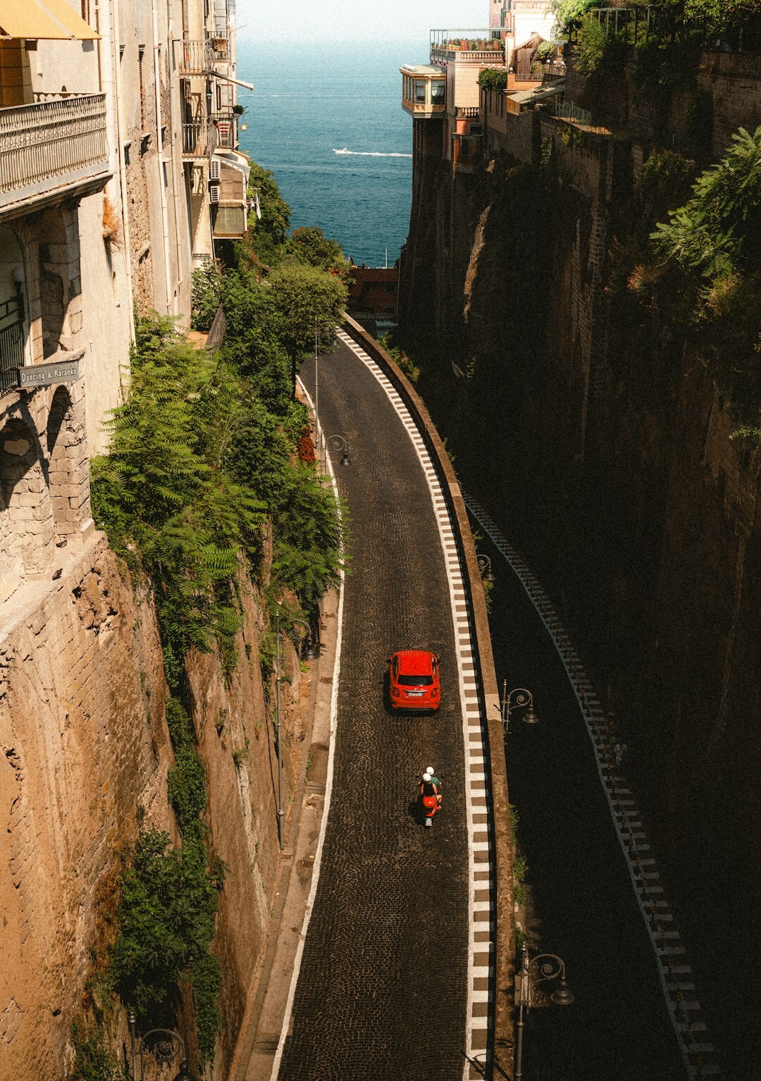 Classic red Italian sports car parked on a rural Uruguayan coastal road