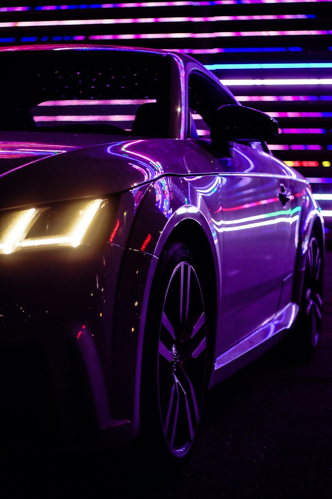 Exotic supercar photographed at night with dramatic reflections and neon light