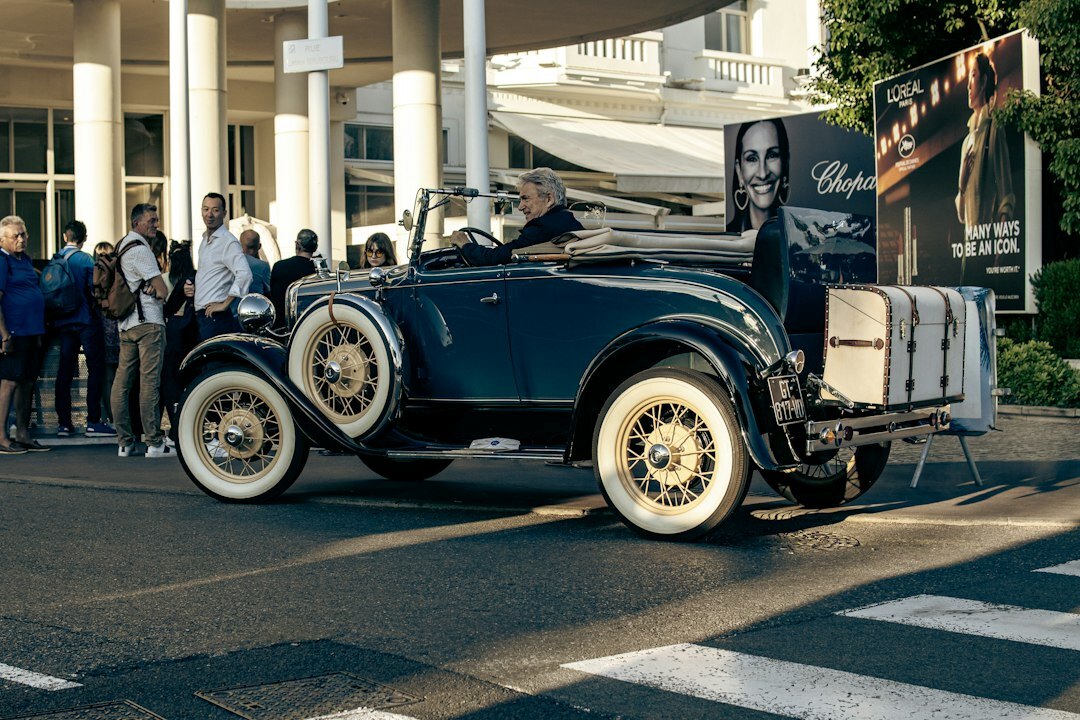 Elegant automobile auction event with a spotlighted vintage car and an attentive crowd