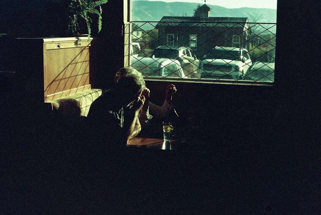 Team of editors examining archival photographs of classic automobiles at a wooden table
